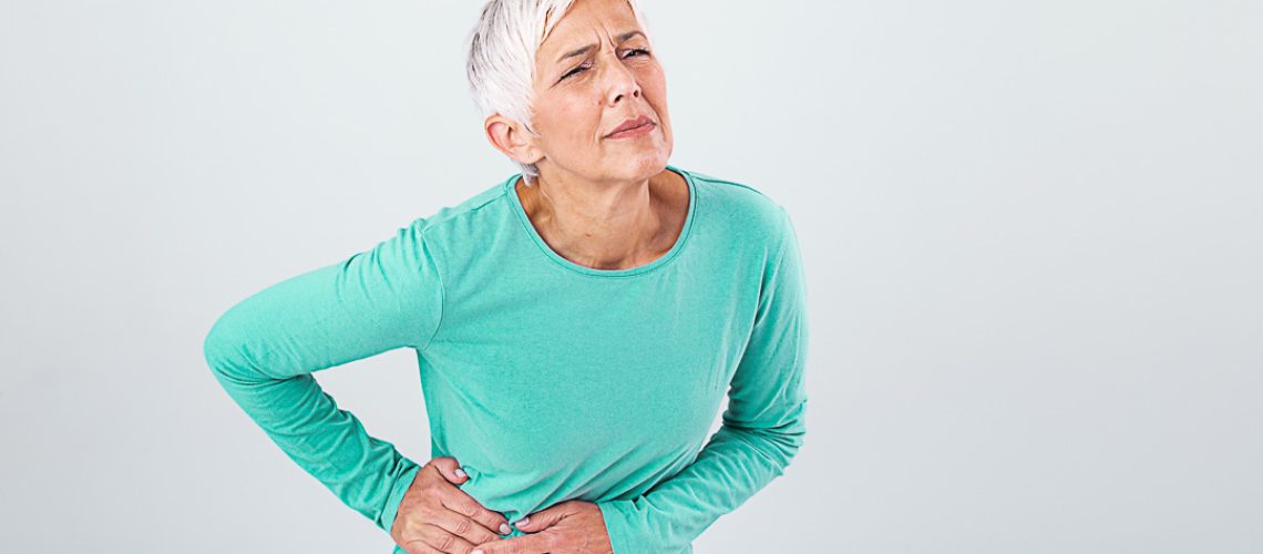 Elderly woman with gray hair touching her aching hip. Upset mature old woman touching back feel hurt osteoarthritis kidney spine ache sore muscles, sad senior lady suffer from lower lumbar pain